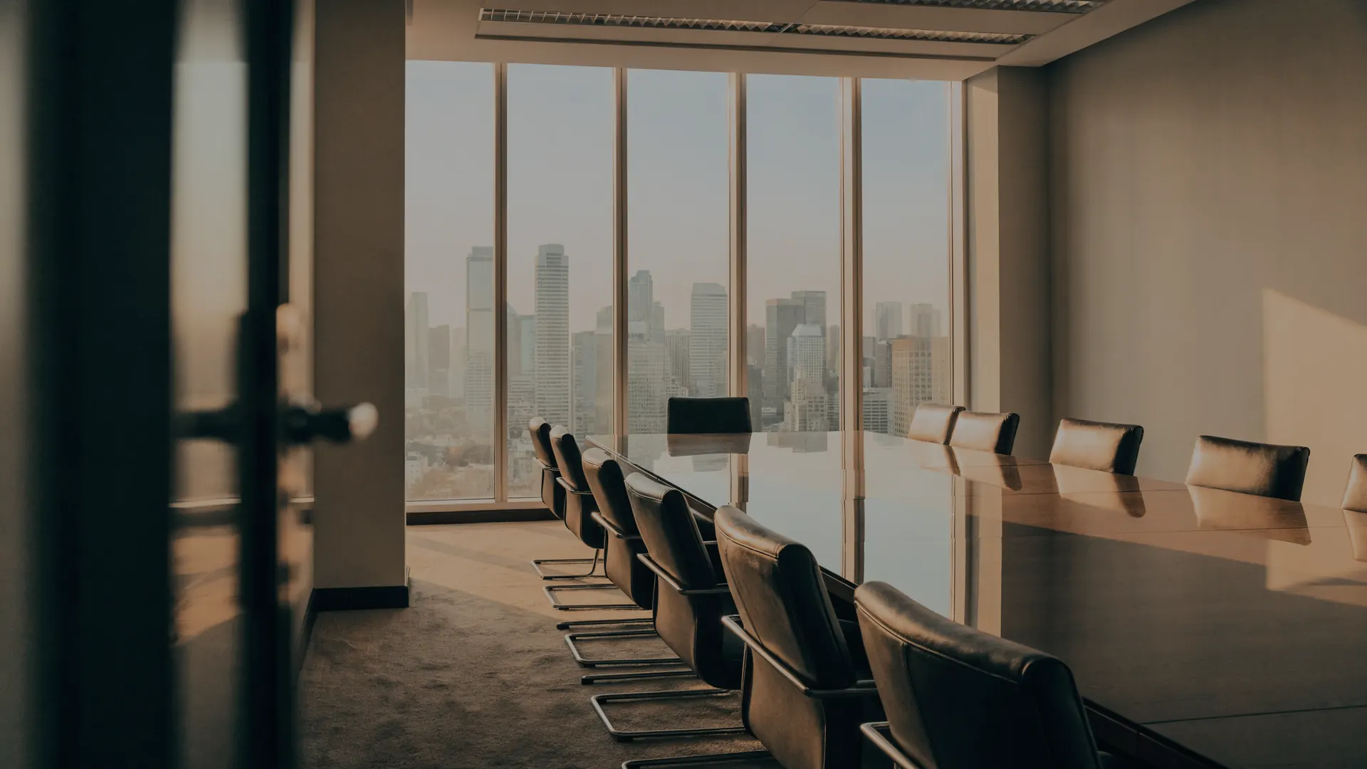 Sala de juntas moderna vista desde la puerta, con la ciudad al fondo